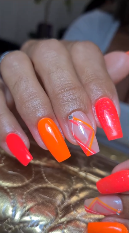 Unhas coffin em laranja e coral neon com linhas geométricas
